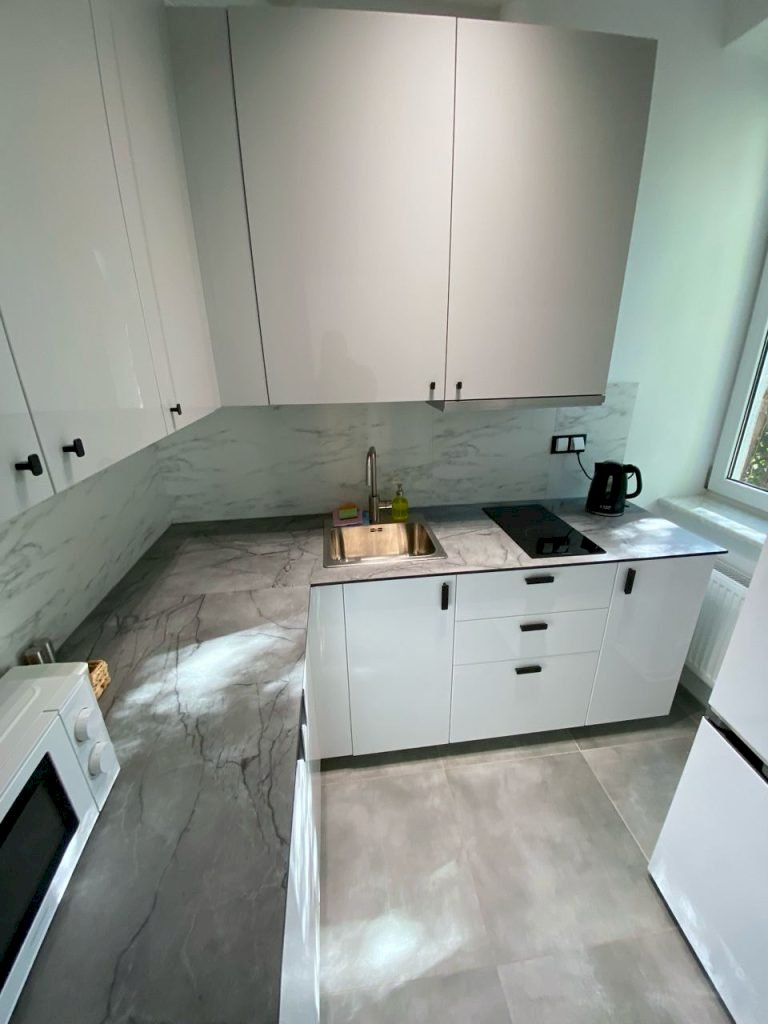 Обладнана кухня з плитою, мікрохвильовкою та холодильником у Student-House Domaniewska у Варшаві