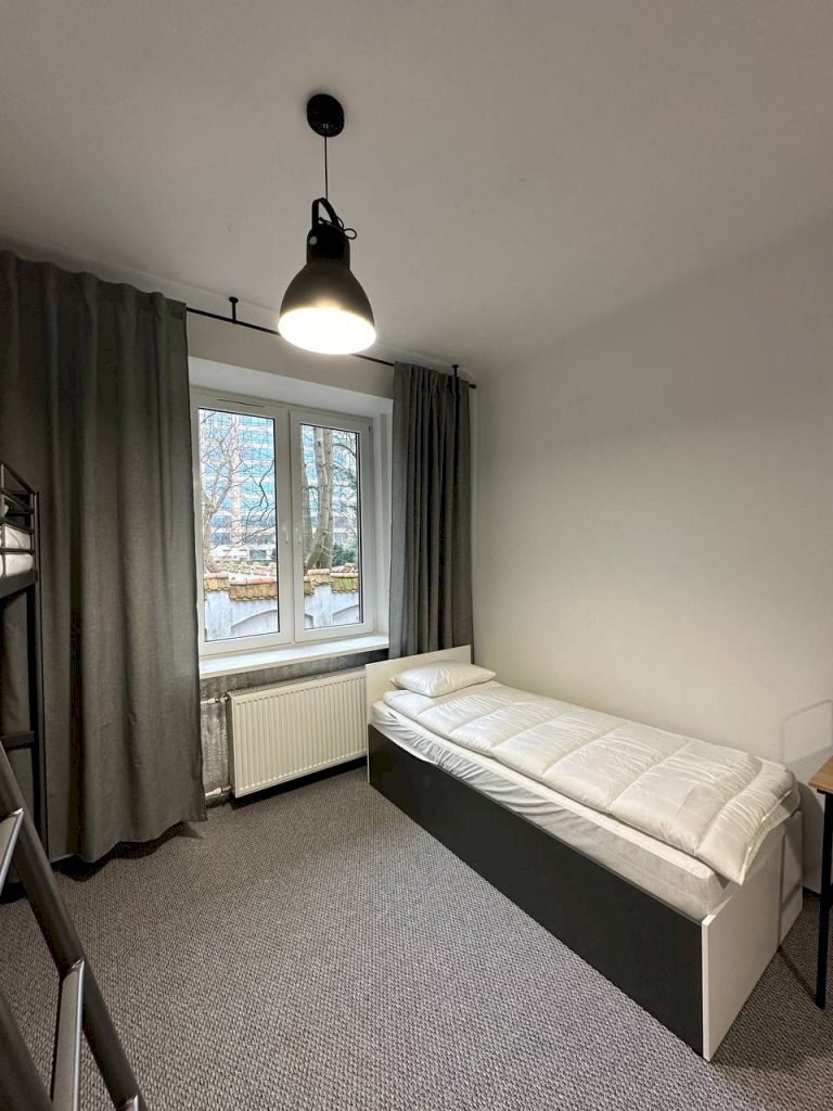 Ліжко біля вікна та письмовий стіл у Student-House Domaniewska, Варшава